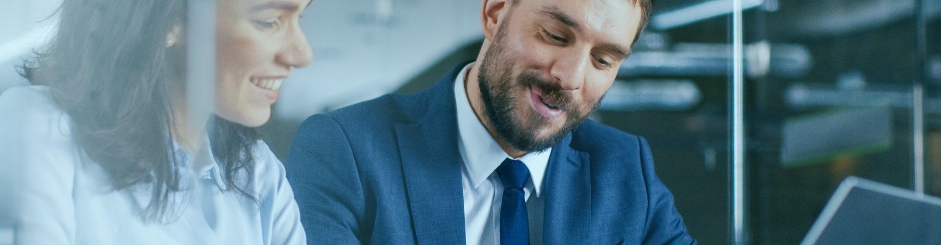 Gestión de Tesorería - Hombre de traje y mujer con camisa sonriendo - Rural Kutxa Gestión de Tesorería - Hombre de traje y mujer con camisa sonriendo - Rural Kutxa