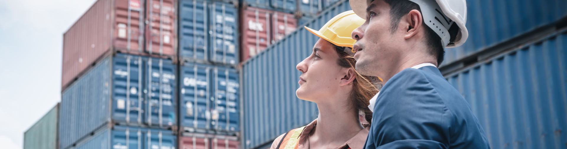 Créditos documentarios de exportación - hombre y mujer con casco rodeados de contenedores