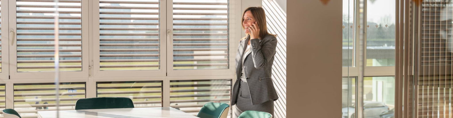 Pagos Empresas - Mujer con traje hablando por el móvil en una oficina - Rural Kutxa Pagos Empresas - Mujer con traje hablando por el móvil en una oficina - Rural Kutxa