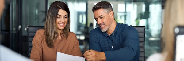 pareja sonriendo revisando documentos a firmar
