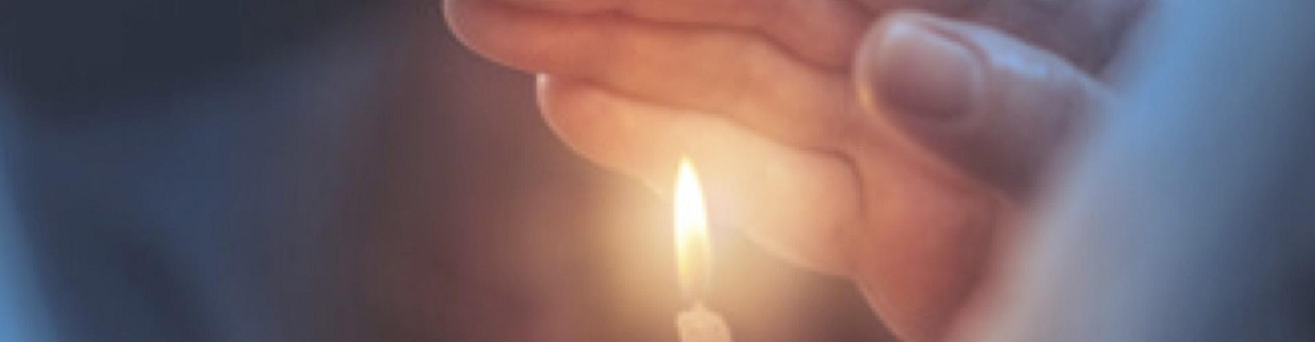 Soluciones Entidades Religiosas cabecera - Mano agarrando una vela encendida - Rural Kutxa