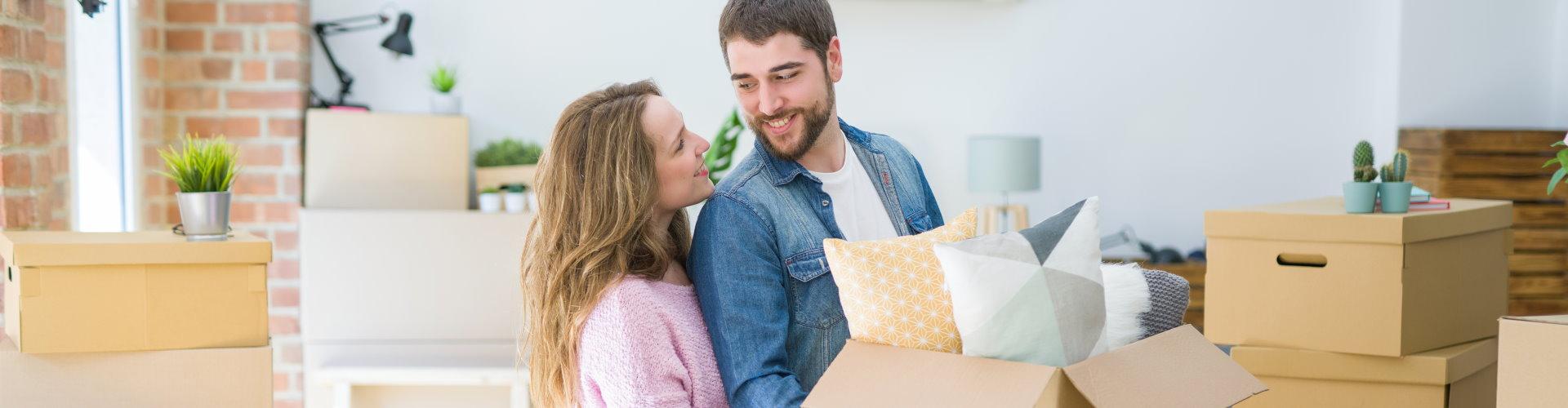 pareja haciendo mudanza mirandose en su nuevo hogar 
