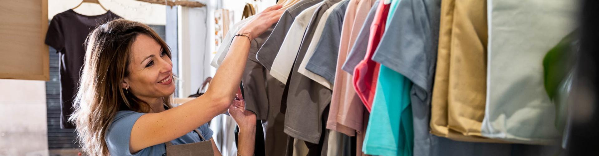 Cuenta Promueve Autónomos - mujer organizando perchero en su tienda de ropa- Rural Kutxa