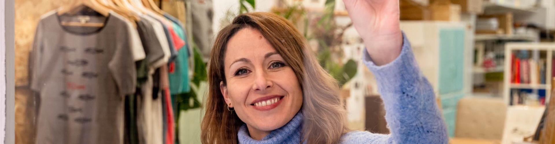 Mujer sonriendo en la puerta de su comercio