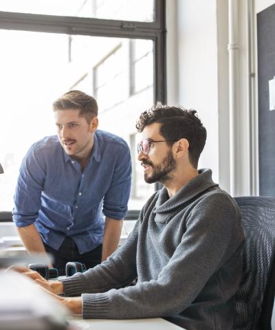 ¿Buscas trabajo? compañeros-trabajando-juntos-en-un-ordenador
