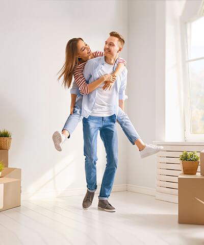 Pareja joven mudandose a su nueva casa o vivienda sonriendo y felices