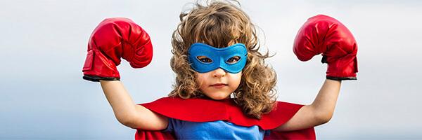 Programa En Marcha Infantil - Niño moreno con un disfraz de superman con un antifaz y guantes de boxeo mientras sonrie