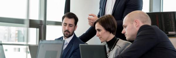 personas-traje-reunidas-en-oficina-mirando-portatil