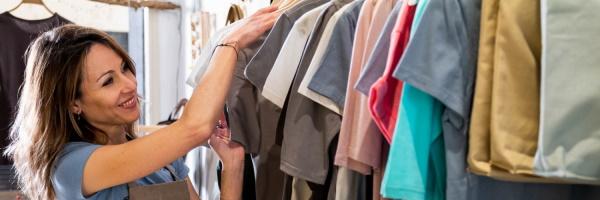 Cuenta Promueve Autónomos - mujer  organizando perchero en su tienda de ropa - Rural Kutxa