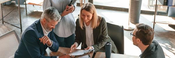 Rural Factoring -Un hombre y dos mujeres hablando en una reunión en la oficina